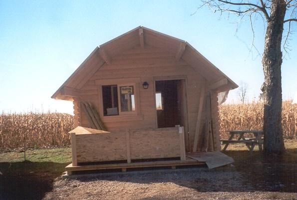 A newly framed wooden cabin beside a cornfield, 2001