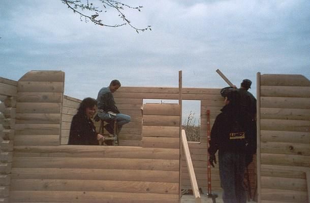 Workers raising log walls, 2001