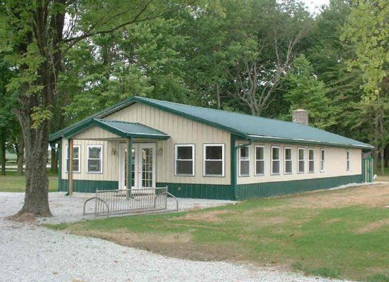 A long single-storey camp building with a green roof