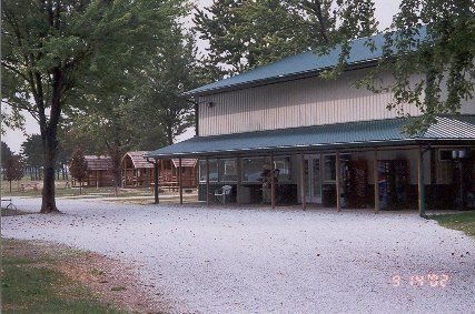 A two-storey camp building with a wraparound porch